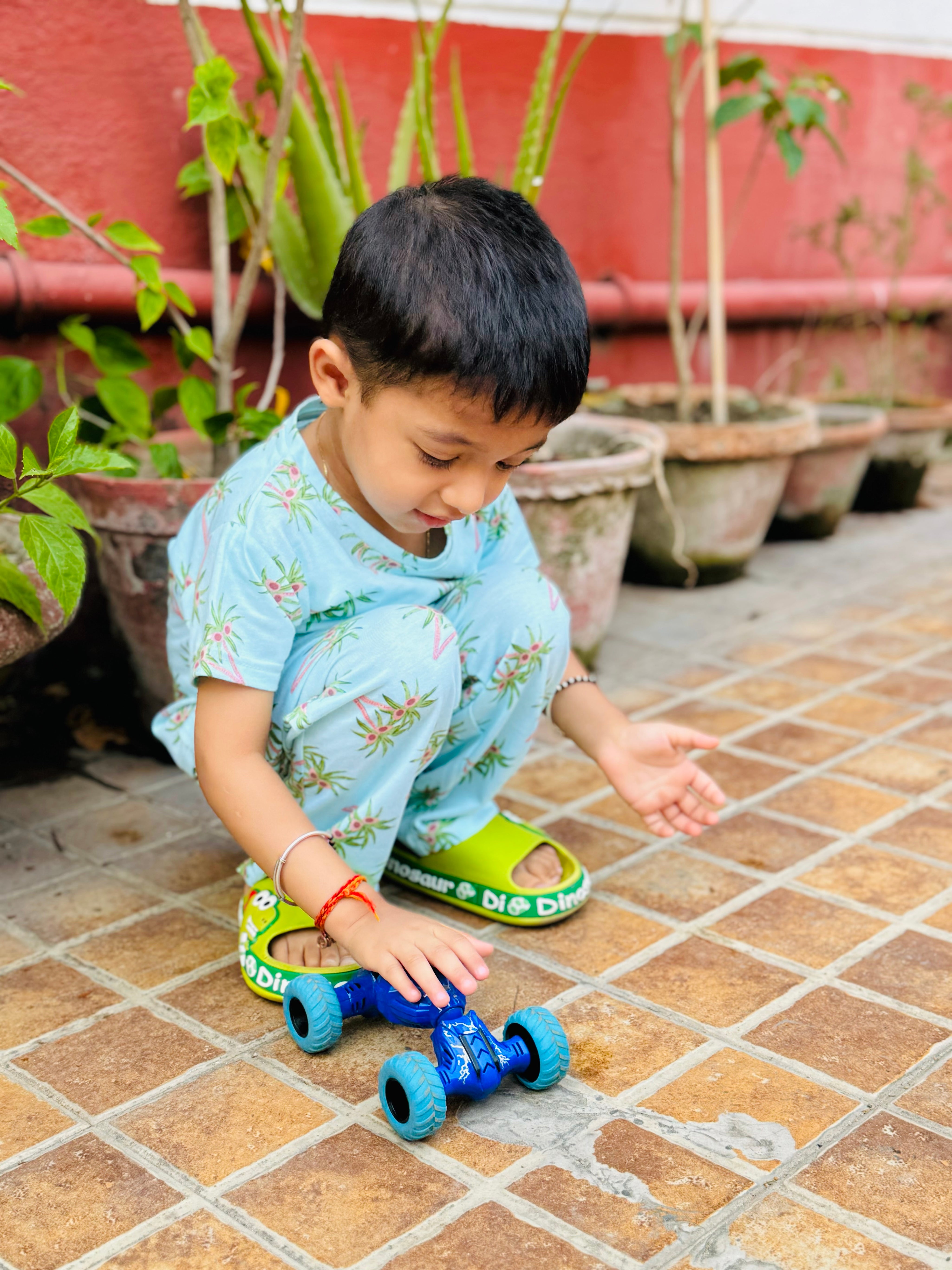 A child wearing unisex topical print nightwear for kids and playing with a toy