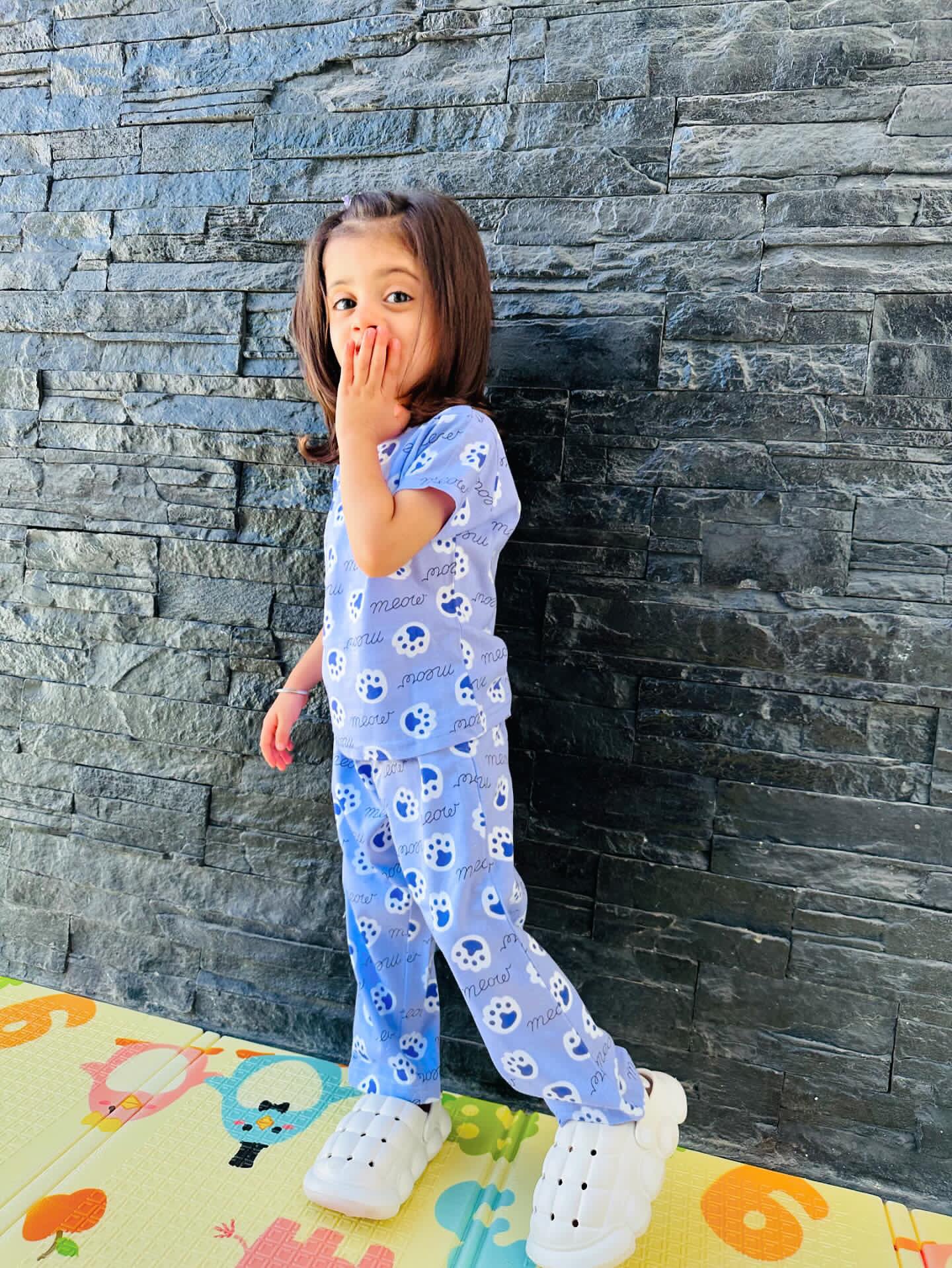 Child in Meow Kids Unisex Nightwear side view with kitten paws print.