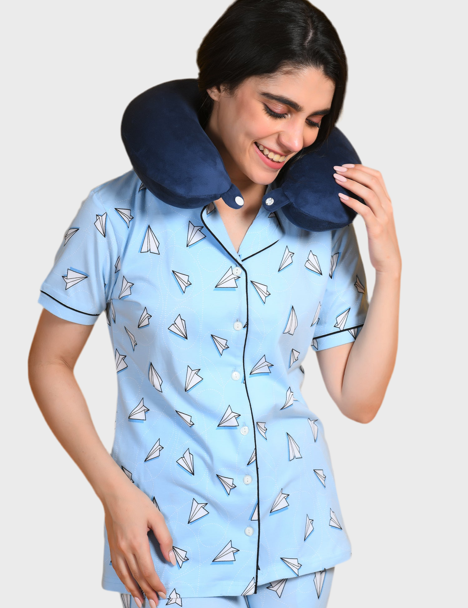 Young girl in a Paper Plane Printed Pyjama Set nightwear by NapStory, standing playfully with her neck rest on.