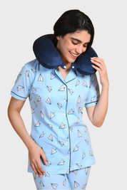 Young girl in a Paper Plane Printed Pyjama Set nightwear by NapStory, standing playfully with her neck rest on.