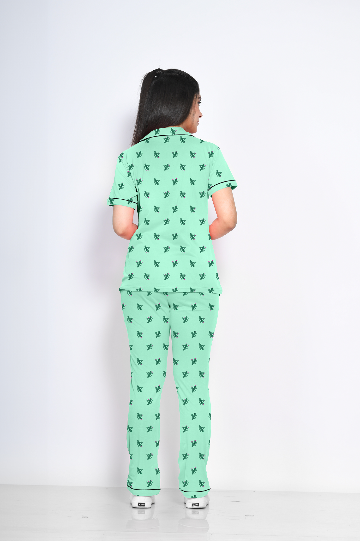 A young lady showing back view of 100% cotton green colour cactus print nightwear pyjama set by NapStory