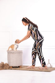 A woman playing with a dog wearing  Dreamy Waves print nightwear pyjama set for women by NapStory