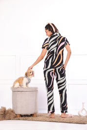 A woman in back pose with a dog wearing  Dreamy Waves print nightwear pyjama set for women by NapStory