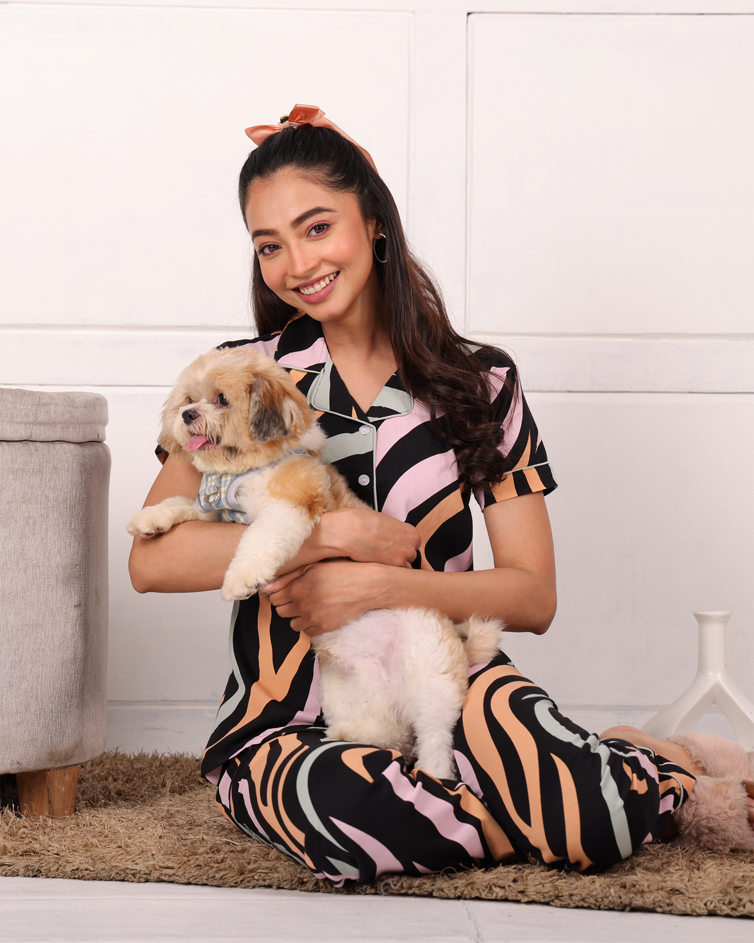 A woman sitting with a dog wearing  Dreamy Waves print nightwear pyjama set for women by NapStory