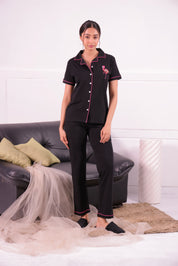 A young woman standing in flamingo embroidery premium pyjama set by NapStory