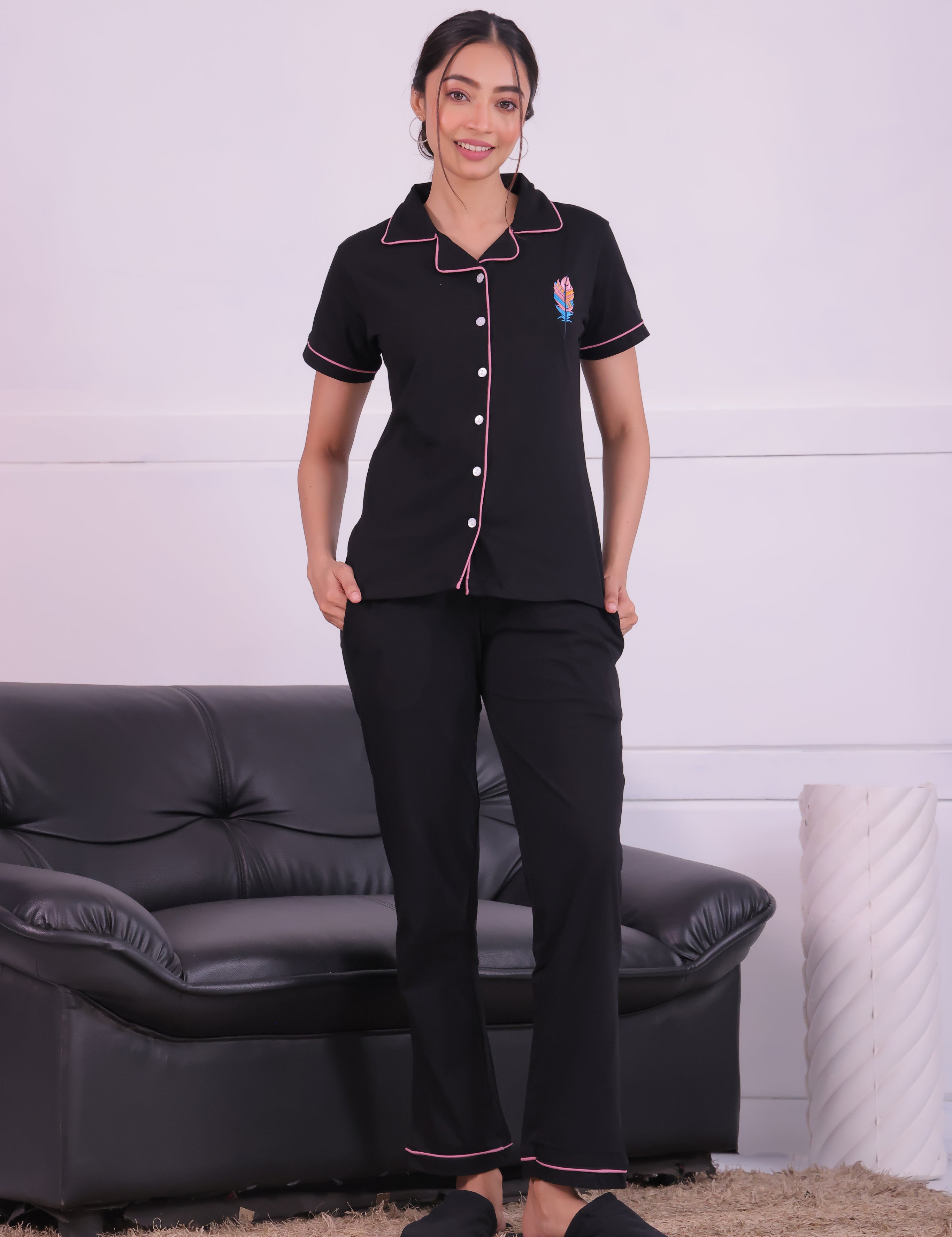 A lady standing next to sofa wearing Feather embroidered premium nightwear pyjama set for women