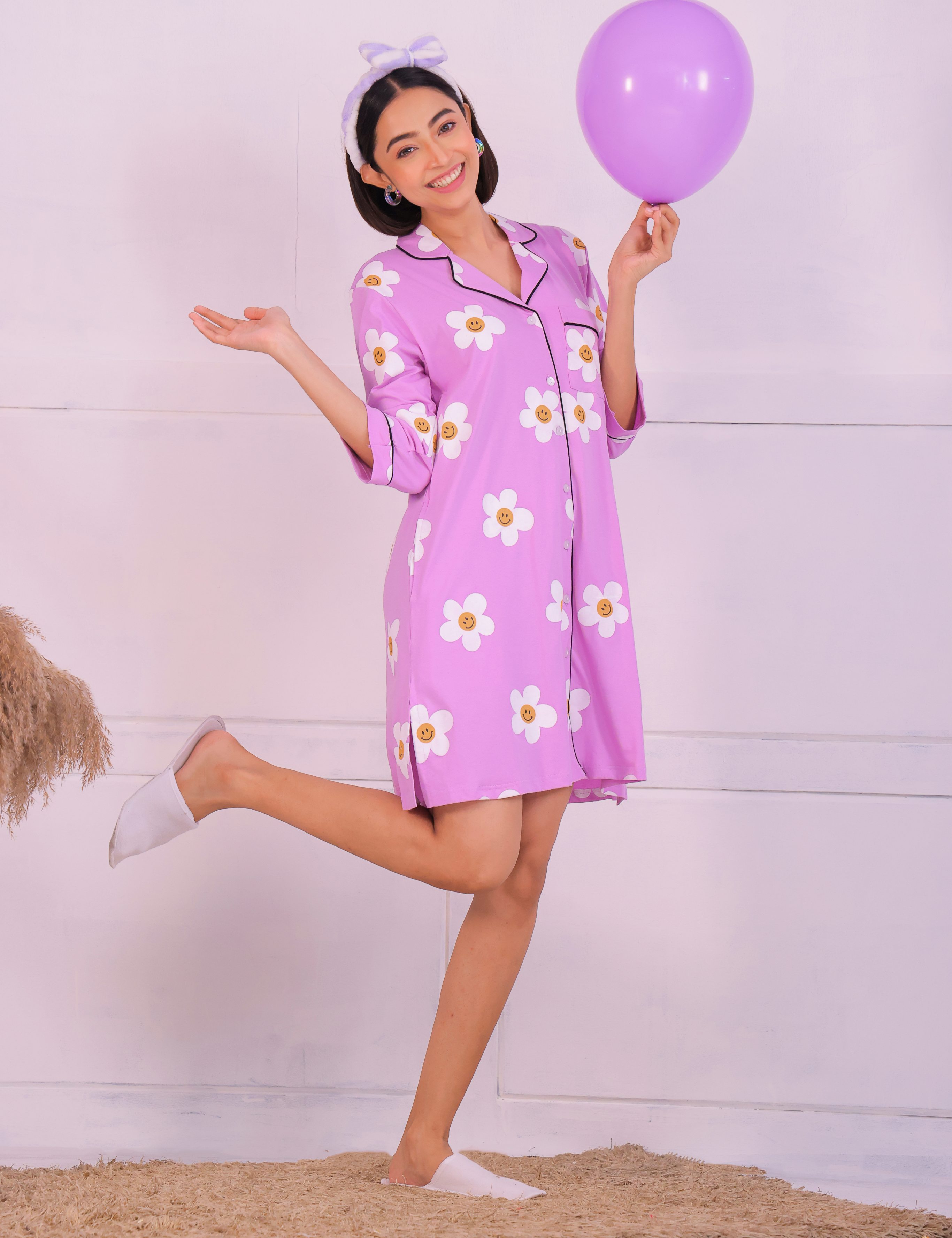 Young girl in a Pink Colour Poppy Print Sleep Shirt nightwear by NapStory, standing playfully with a balloon.