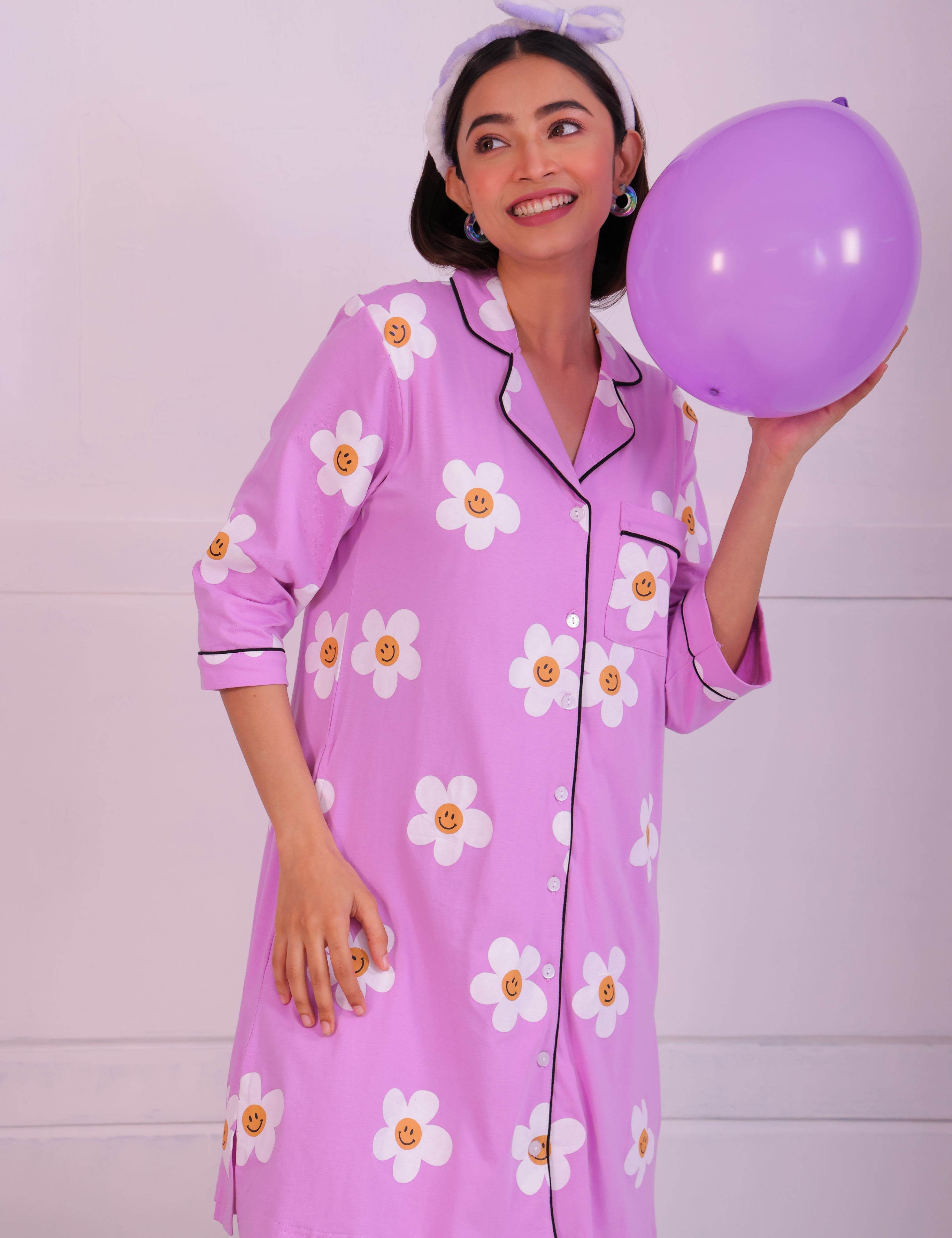 Young girl in a Pink Colour Poppy Print Sleep Shirt nightwear by NapStory, standing with a balloon in hand.