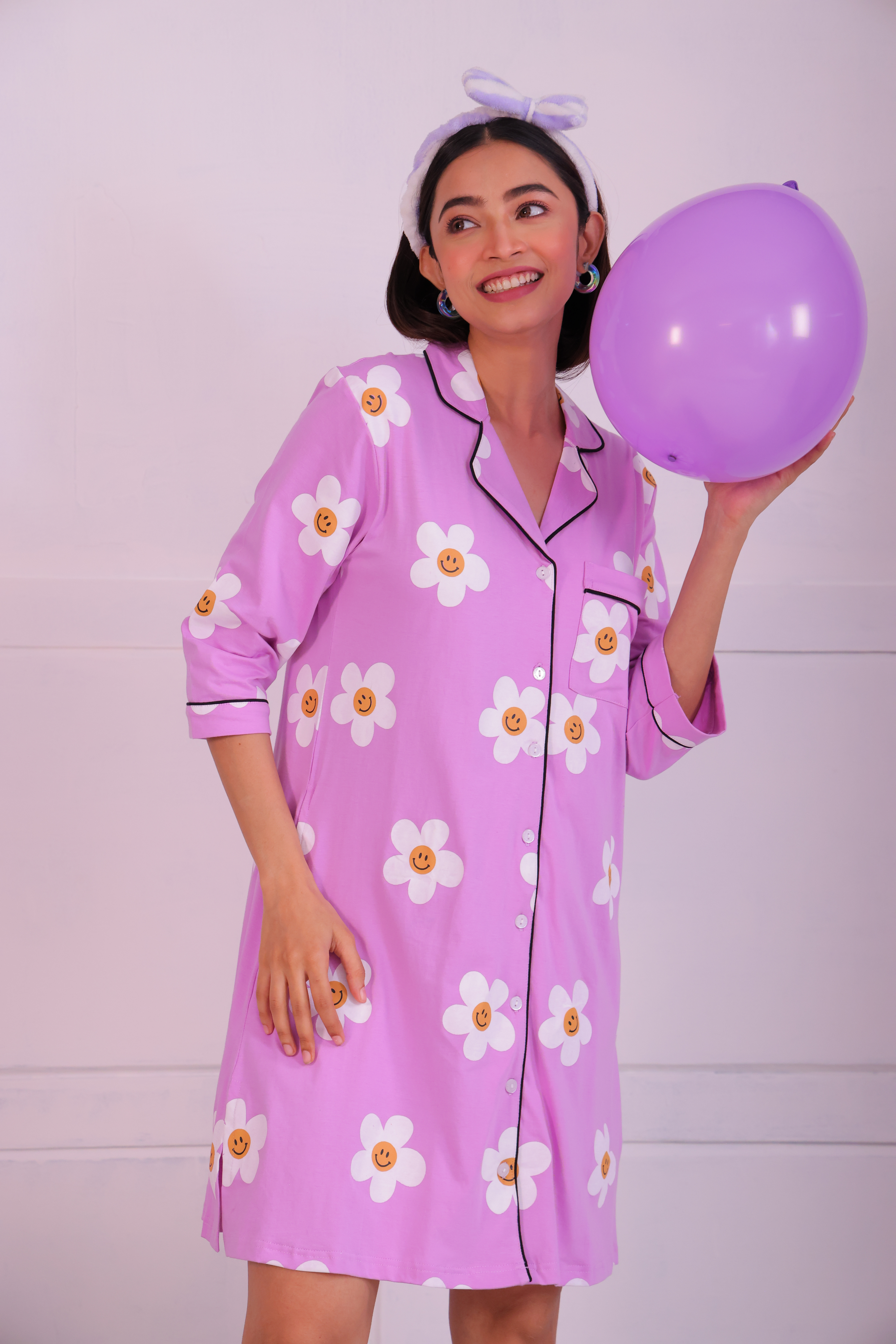 Young girl in a Pink Colour Poppy Print Sleep Shirt nightwear by NapStory, standing with a balloon in hand.