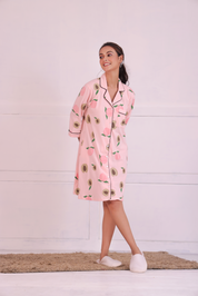 Young girl in a Pink Colour Peach Print Sleep Shirt nightwear by NapStory, standing cheerfully with legs crossed.