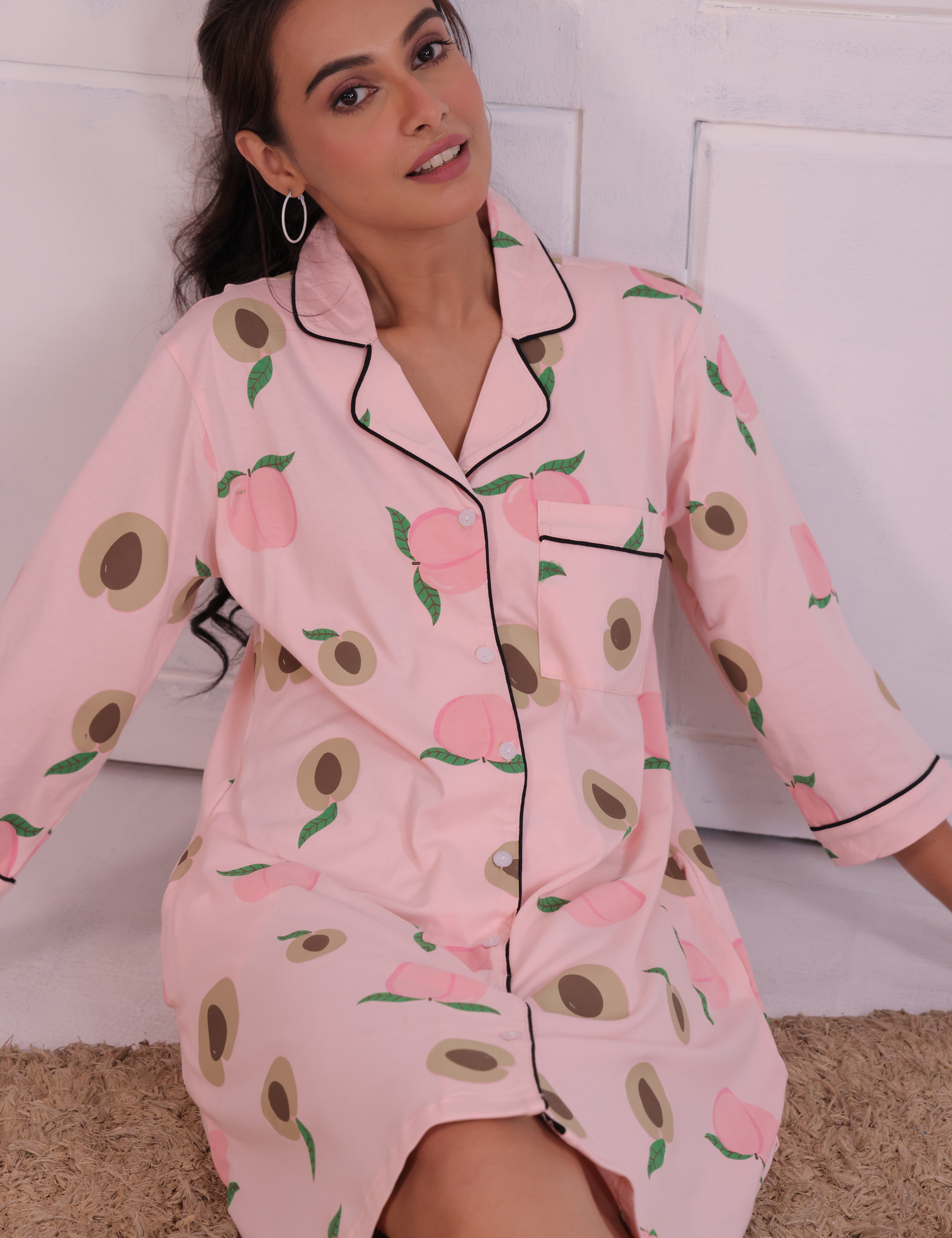 Young girl in a Pink Colour Peach Print Sleep Shirt nightwear by NapStory, sitting confidently.