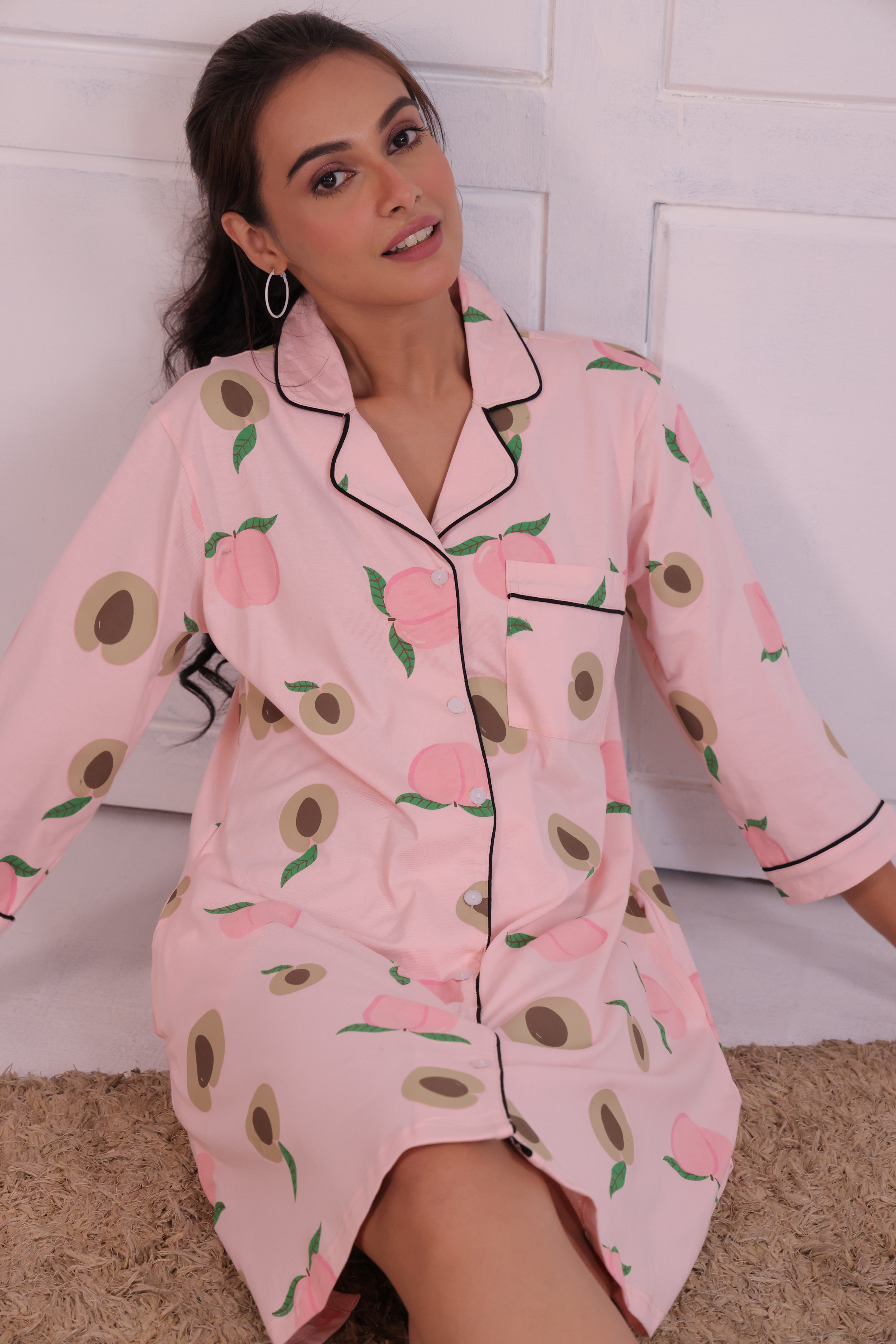 Young girl in a Pink Colour Peach Print Sleep Shirt nightwear by NapStory, sitting confidently.