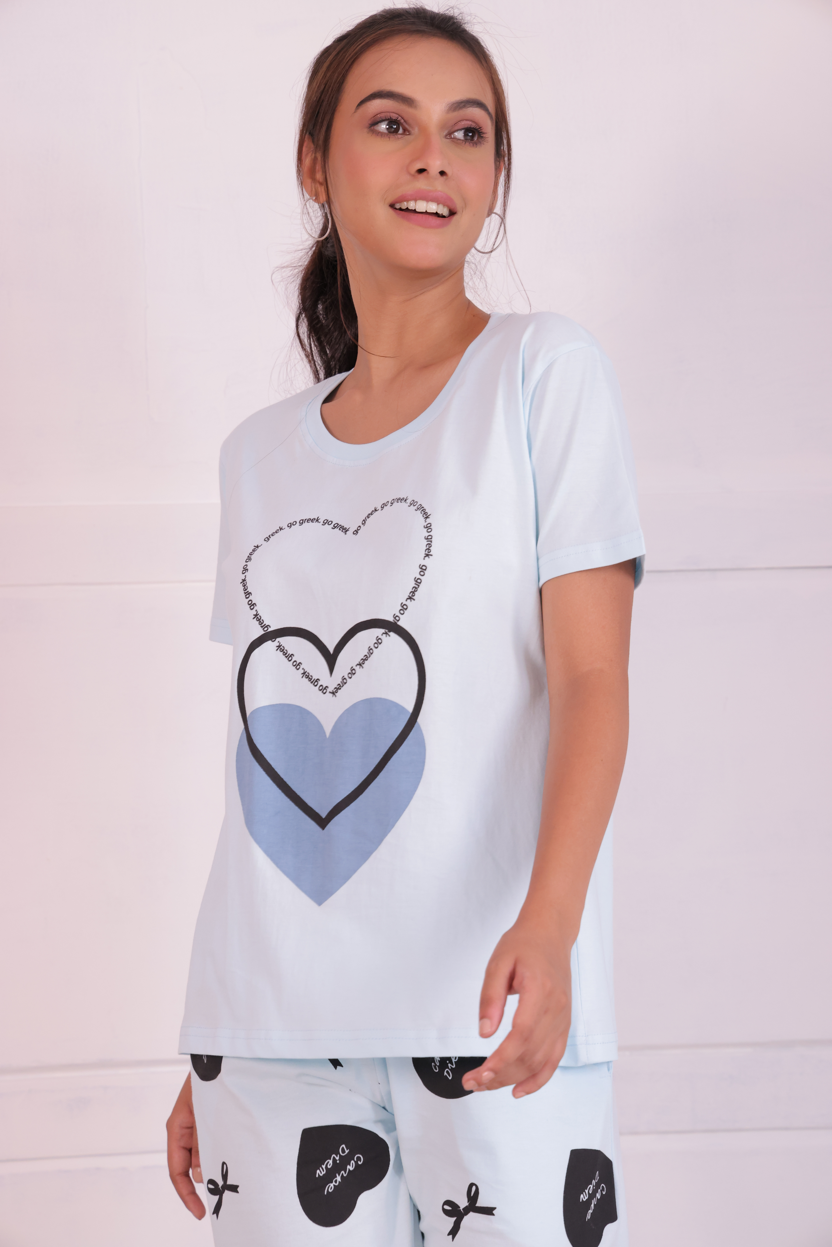 A young lady in stylish white colour bows and heart print nightwear t-shirt pyjama set.