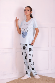 A young woman standing in stylish white colour bows and heart print nightwear t-shirt pyjama set.