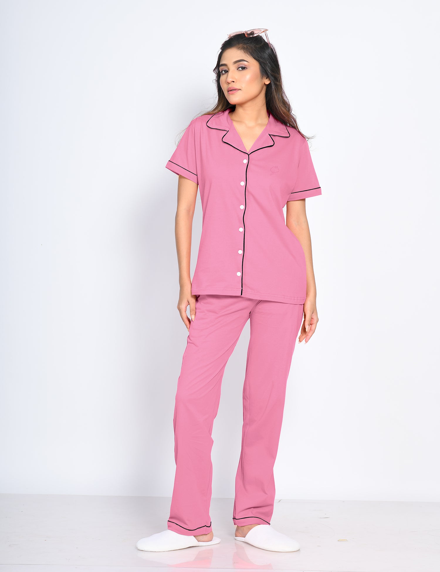 A young woman confidently posing in a Pink Solid Pyjama Set by NapStory, showcasing a chic yet relaxed look, ideal for ultimate comfort and elegance.