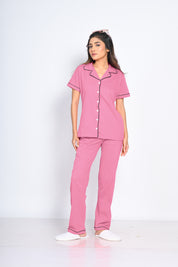 A young woman confidently posing in a Pink Solid Pyjama Set by NapStory, showcasing a chic yet relaxed look, ideal for ultimate comfort and elegance.