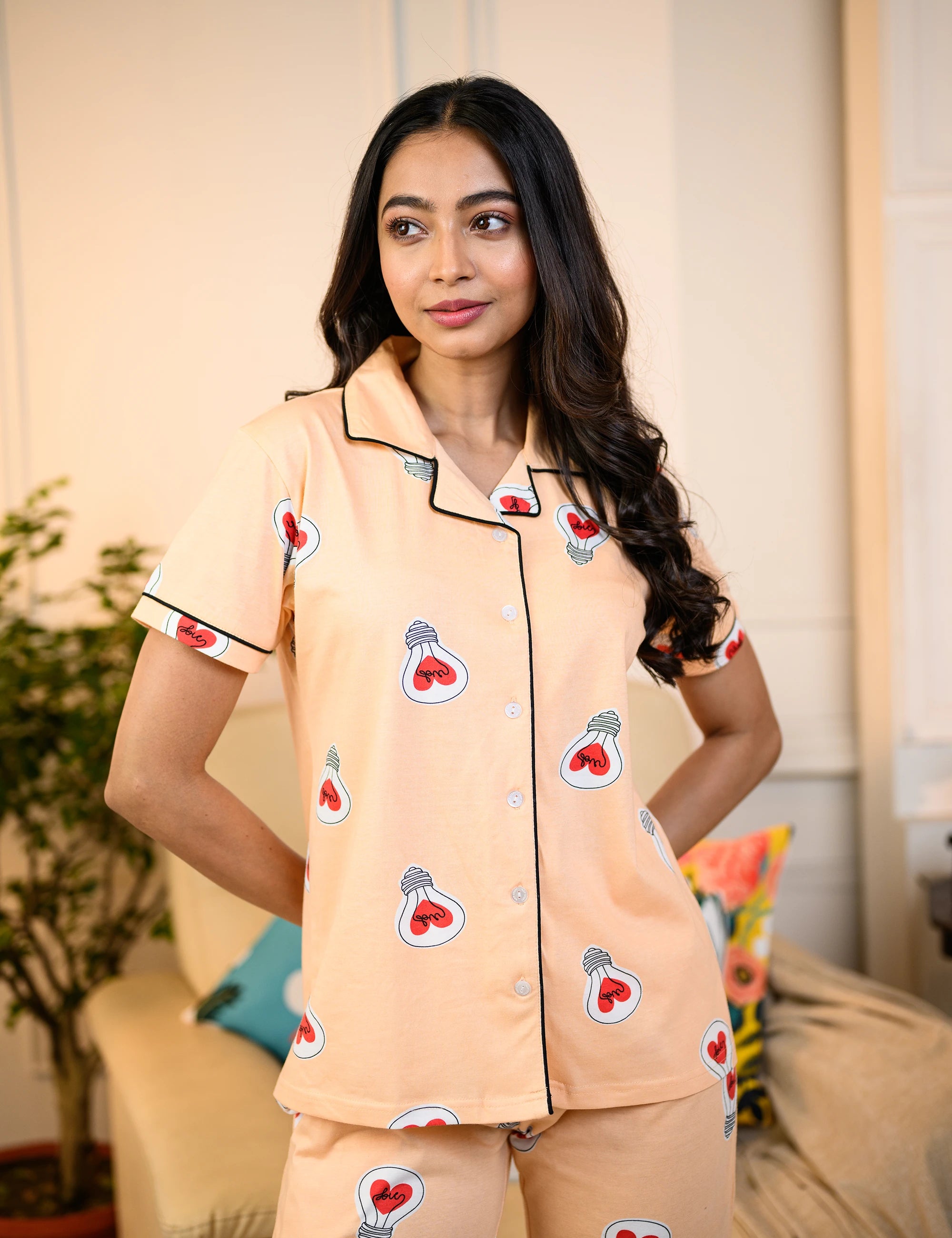 Woman wearing a peach Love Bulb Print Pyjama Set by NapStory, featuring cute bulb designs, styled for nightwear or loungewear.