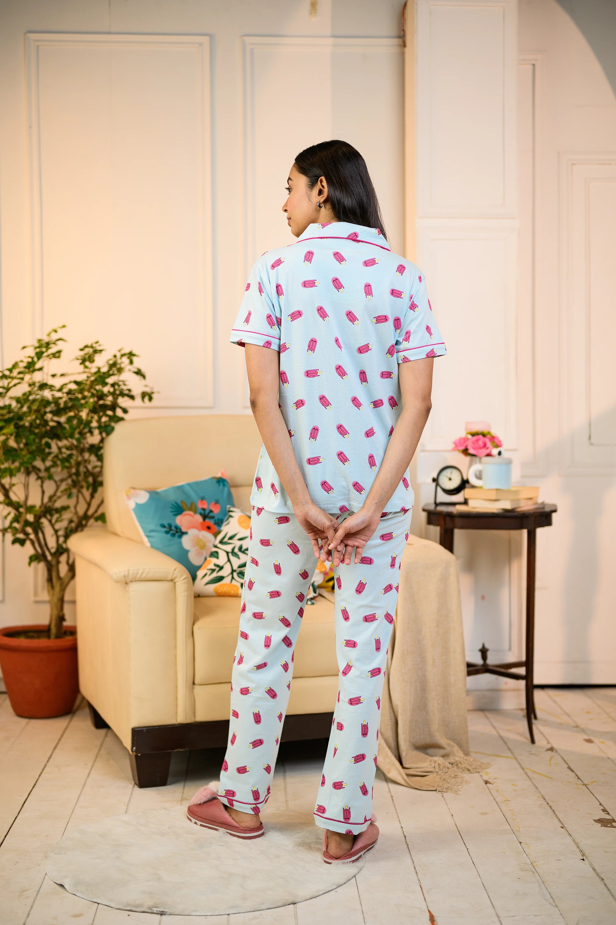 A woman stands with her back to the camera, highlighting the comfortable fit and playful design of the Popsicle Print Pyjama Set by NapStory.