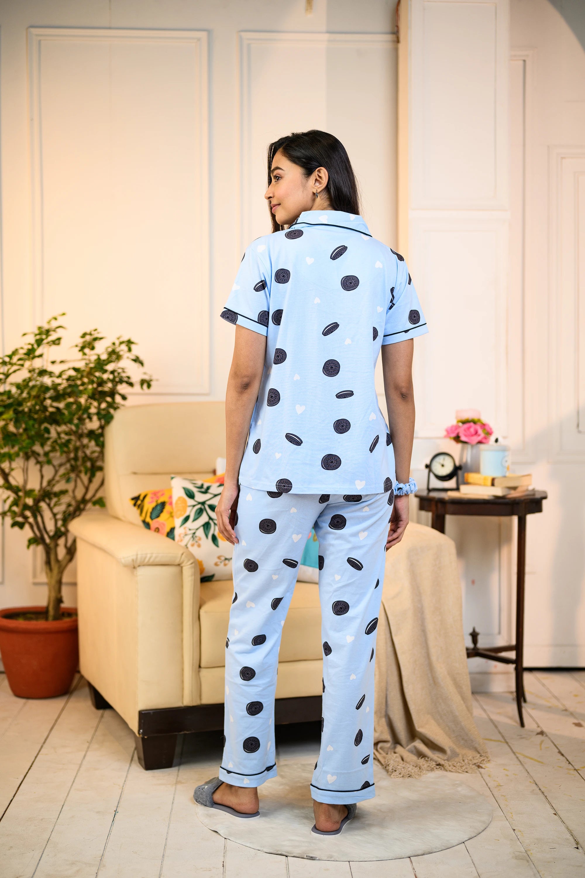 Back view of a woman in a blue Oreo Print Pyjama Set by NapStory, featuring playful cookie patterns, styled for casual loungewear.