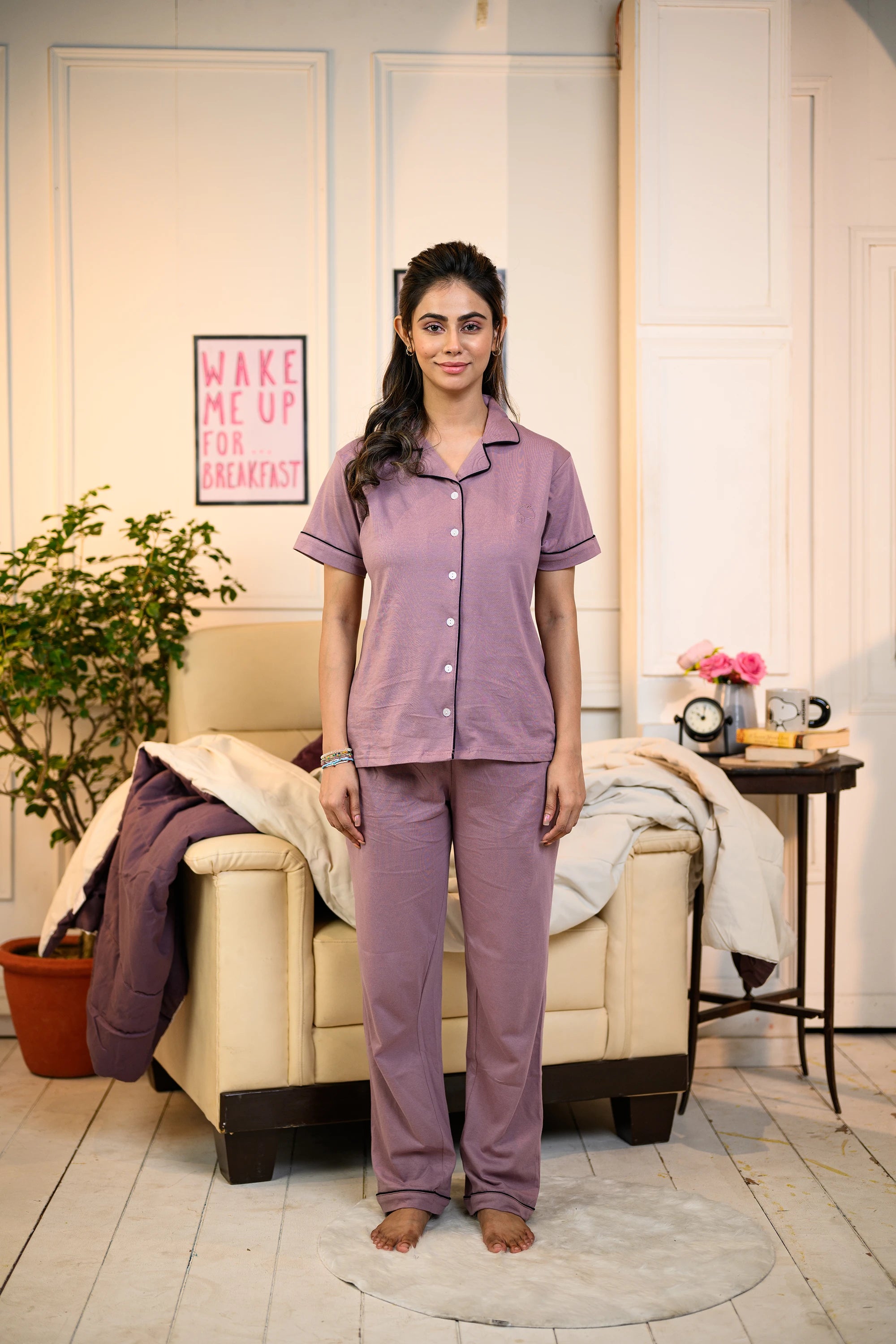 A young woman in a full frontal pose, wearing Dusty Lilac Solid Nightwear by NapStory, with a bright smile.