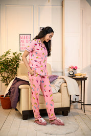 Young woman in a pink Bandage Print Pyjama Set by NapStory, smiling and looking down