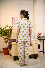 Rear angle of a woman dressed in a playful Kiwi Print Pyjama Set by NapStory, highlighting the breathable fabric and fun pattern.