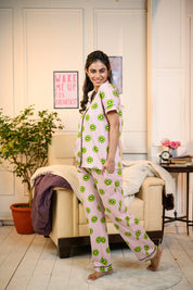 Side pose of a woman wearing a pink Kiwi Print Pyjama Set by NapStory, featuring playful kiwi designs, perfect for lounging or casual nightwear.