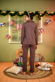 A woman in a rear view, wearing a Taupe Brown Full Sleeve Nightsuit Set with a button-up top and matching pyjama pants