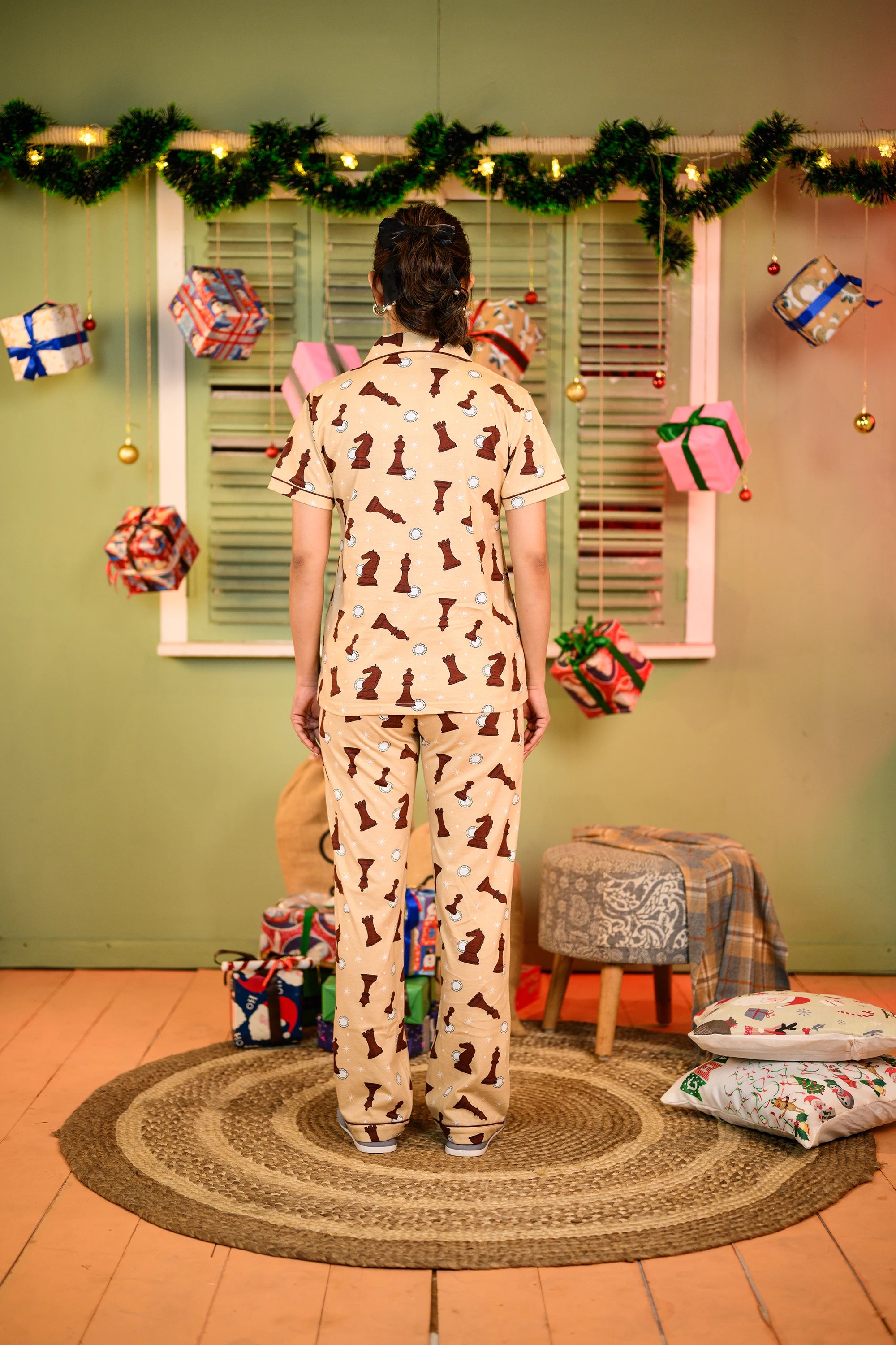 A woman stands with her back turned, showcasing the Chess Print Pyjama Set by NapStory.