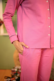 A close-up of the pink full-sleeve pyjama set, highlighting the pocket detail and buttons, with a hand resting on the pocket