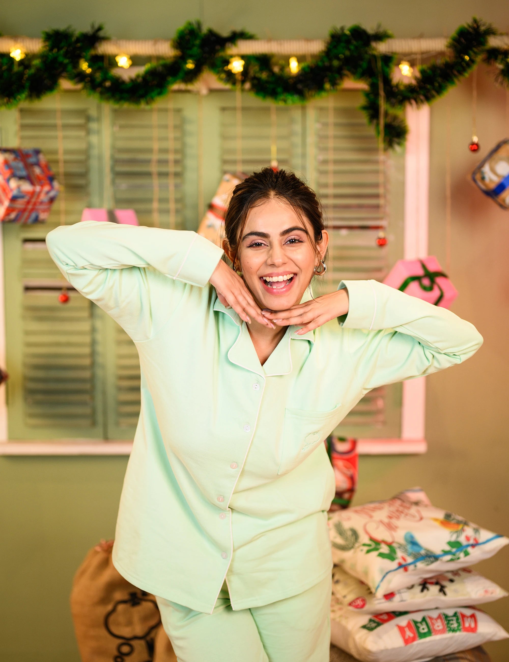 Young woman smiling and playfully posing in misty mint fleece full sleeve night suit set.