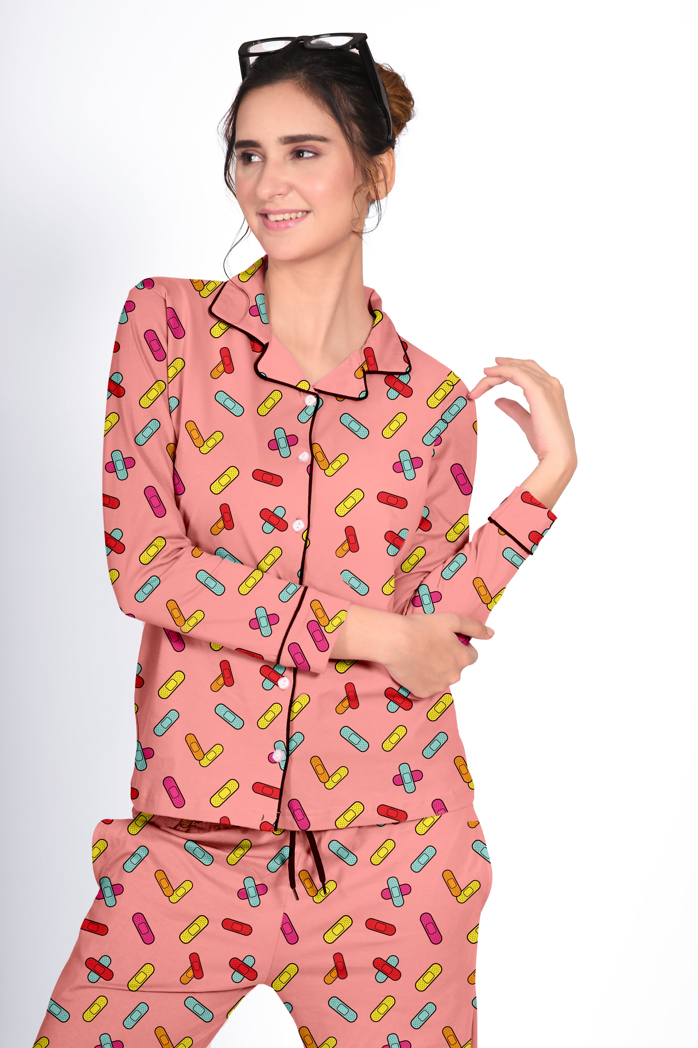 Lady in a pink Bandages Print Full Sleeves Pyjama Set by NapStory, posing with a playful smile and stylish look.