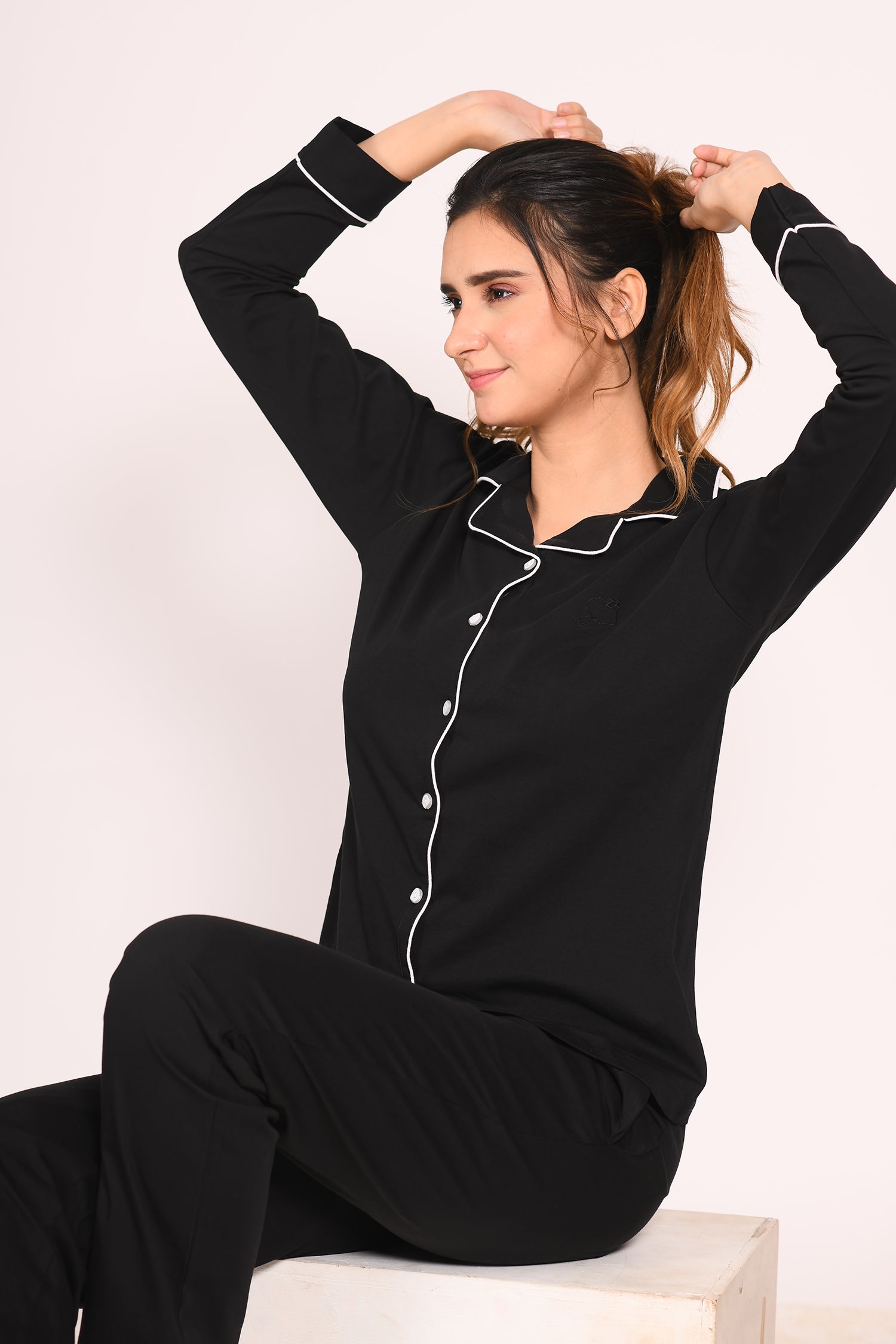 Woman sitting comfortably in a full-sleeve 100% cotton black nightsuit set by Napstory