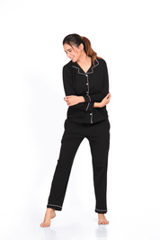 Woman showing the front view of a plain full-sleeve 100% cotton black nightsuit set by Napstory.