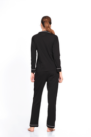 Woman showing the backside of a plain full-sleeve 100% cotton black nightsuit set by Napstory.