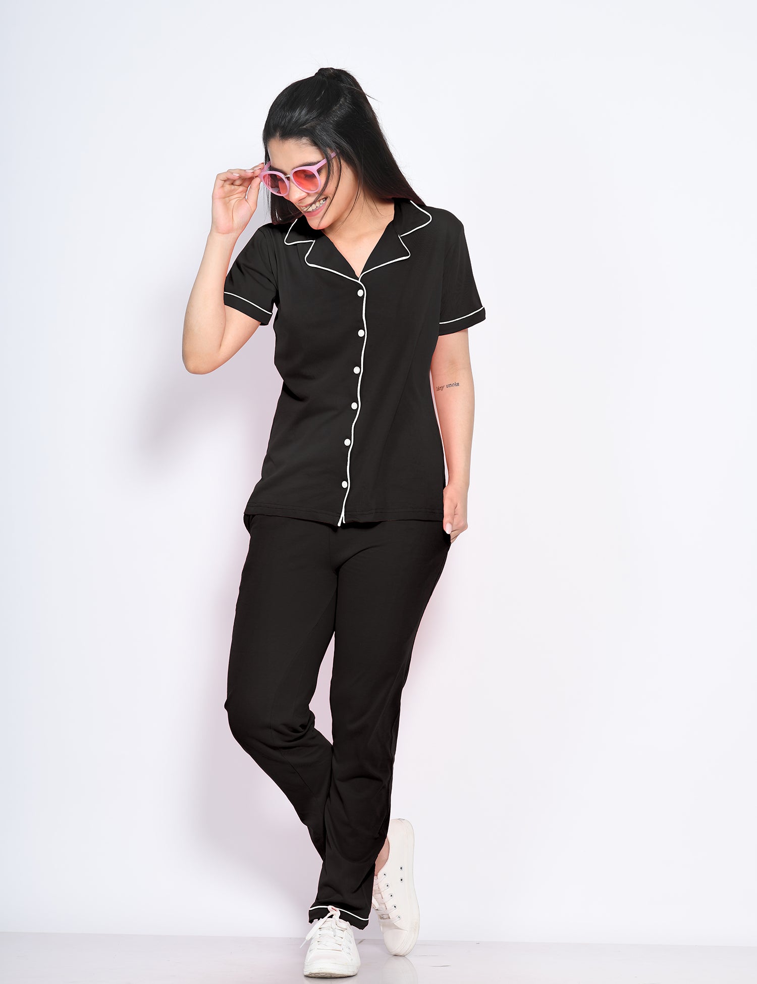 A woman flaunting her stylish and trendy solid black colour nightwear pyjama and shirt set