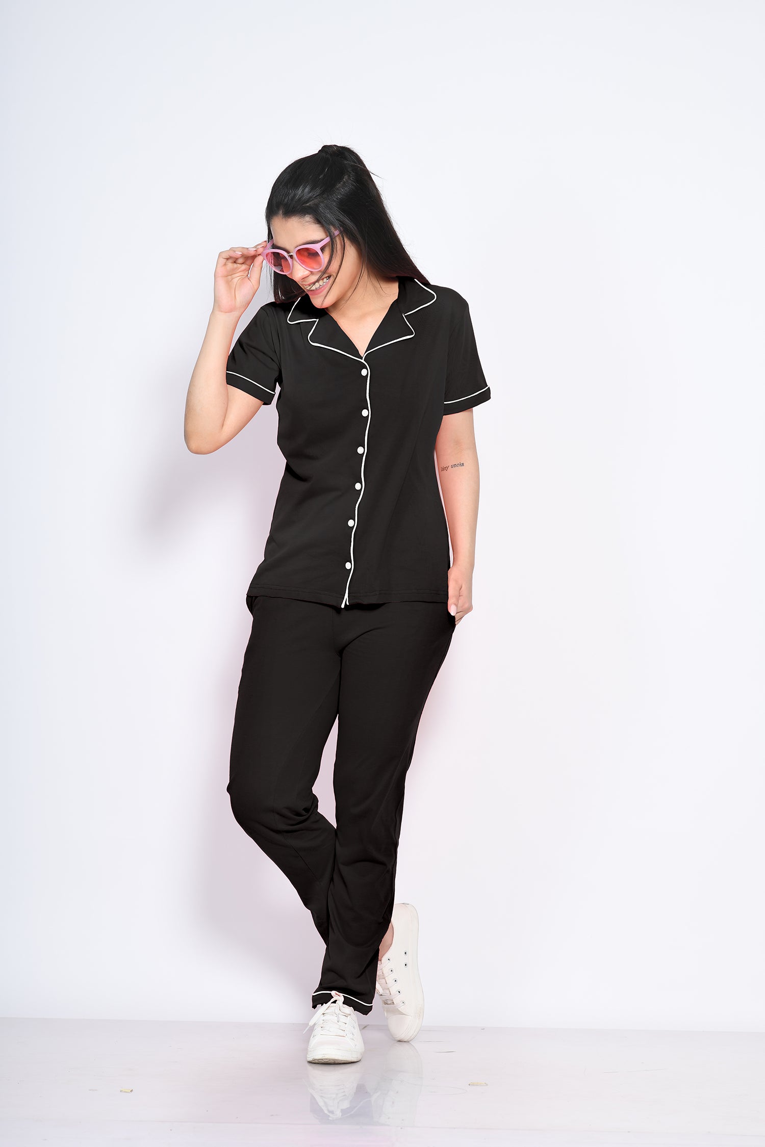 A woman flaunting her stylish and trendy solid black colour nightwear pyjama and shirt set