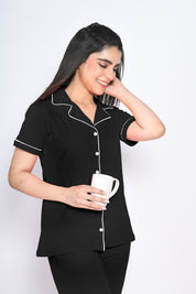 A woman in solid black colour nightwear pyjama and shirt set