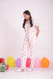 A girl standing in side pose wearing a Lovebug print nightwear pyjama set by NapStory