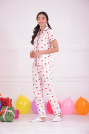 A young girl standing in side pose wearing a Lovebug print nightwear pyjama set by NapStory