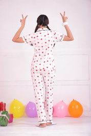 A young girl standing in back pose wearing a Lovebug print nightwear pyjama set by NapStory